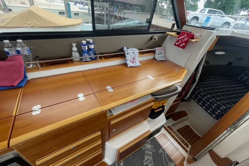 Slide: The Image of 2022 Cutwater C-30 Sedan interior with wooden cabinetry and nautical-themed decor. - 35