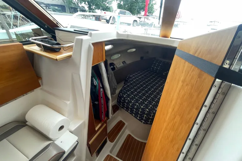 Slide: The Image of 2022 Cutwater C-30 Sedan interior with cozy cabin and nautical-themed bedding. - 39