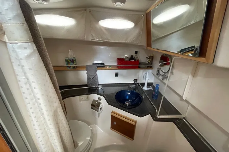 Slide: The Image of 2022 Cutwater C-30 Sedan bathroom with modern sink, mirror, and storage shelves. - 45