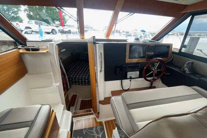 Slide: The Image of 2022 Cutwater C-30 Sedan interior with helm, navigation screens, and cozy cabin. - 49