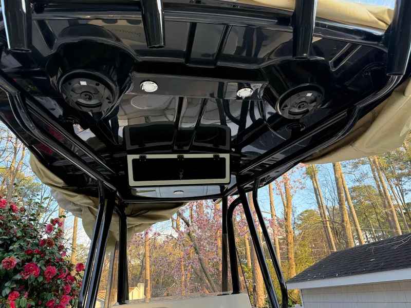 Slide: The Image of 2021 Carolina Skiff 23 Ultra Elite boat canopy with speakers and lights, surrounded by trees. - 8