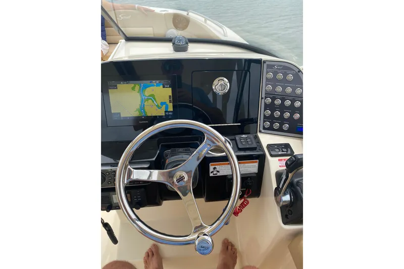 Slide: The Image of 2019 Scout 255 Dorado boat dashboard with steering wheel and navigation display. - 12
