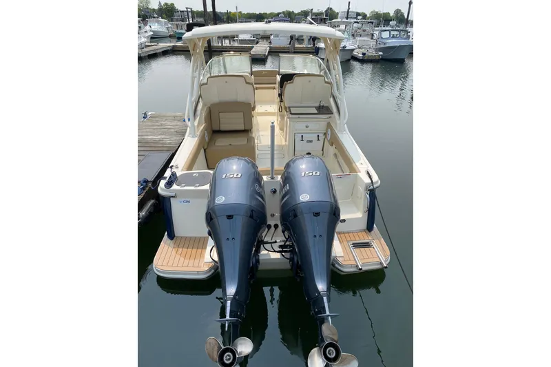 Slide: The Image of 2019 Scout 255 Dorado boat with dual Yamaha 150 engines docked at marina. - 2