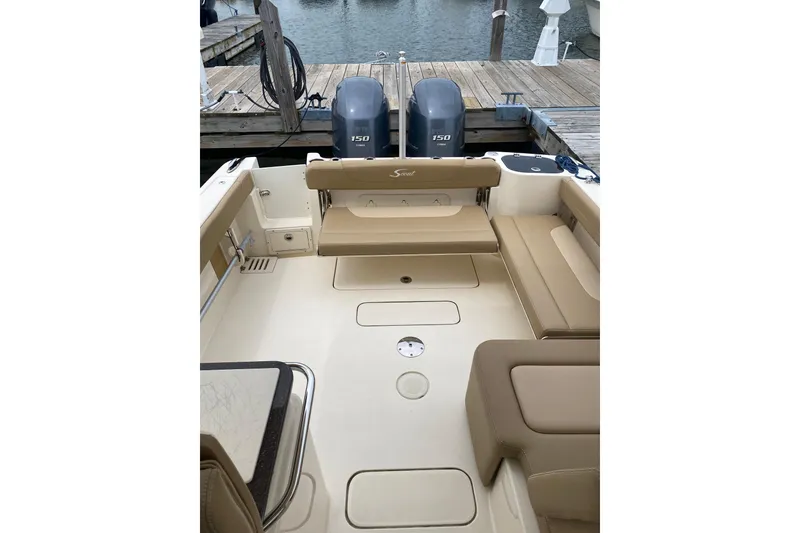 Slide: The Image of 2019 Scout 255 Dorado boat interior with seating and twin 150 engines at dock. - 8
