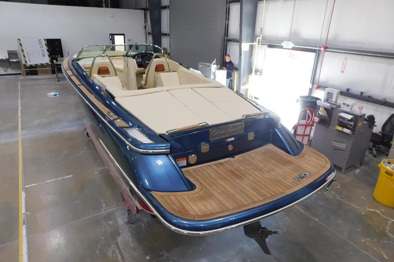 Slide: The Image of 2025 Chris-Craft Launch 27 boat in a workshop, featuring elegant design and teak decking. - 11