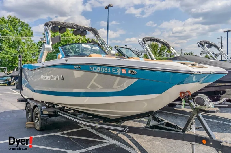 Slide: The Image of 2022 MasterCraft X24 boat on trailer, displayed outdoors under a sunny sky. - 10