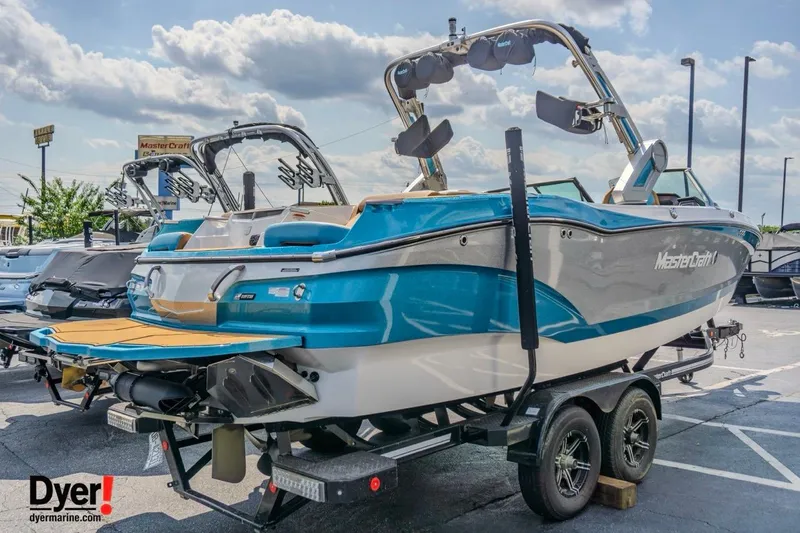 Slide: The Image of 2022 MasterCraft X24 boat on trailer, blue and white design, displayed outdoors. - 8