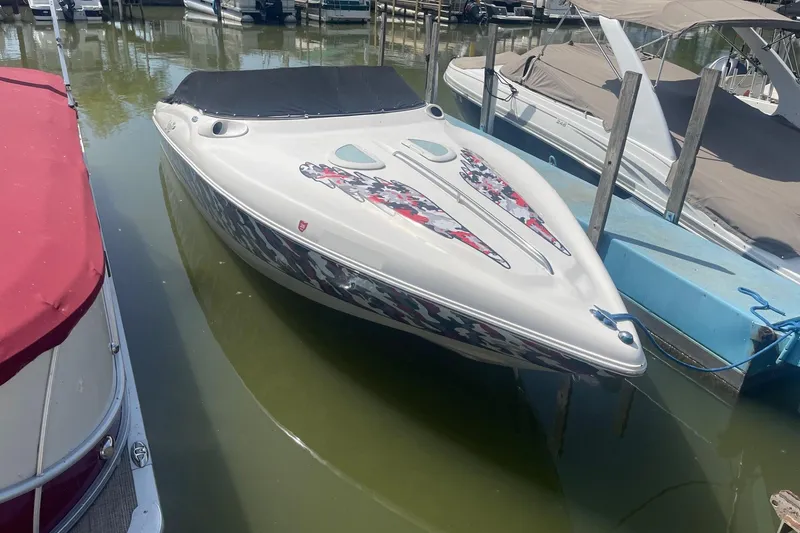 The Image of 2001 Rinker 262 Captiva boat docked in marina, featuring sleek design and vibrant graphics. - 1