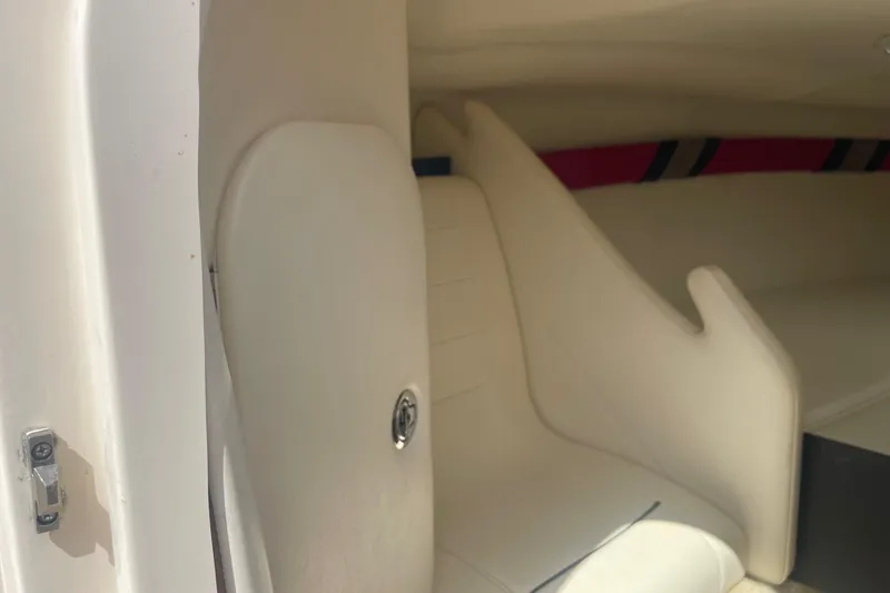 Slide: The Image of 2001 Rinker 262 Captiva interior with white seating and storage compartment. - 17