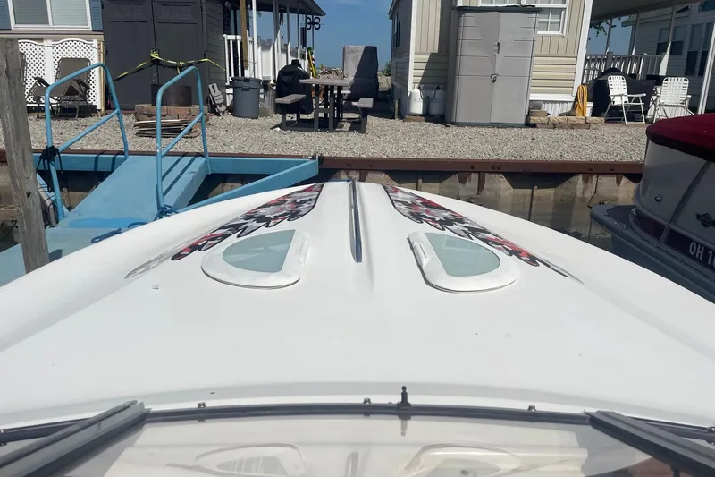 Slide: The Image of 2001 Rinker 262 Captiva boat docked near waterfront homes. - 5