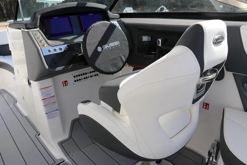 Slide: The Image of 2026 Chaparral 270 OSX boat cockpit with modern controls and white seating. - 15