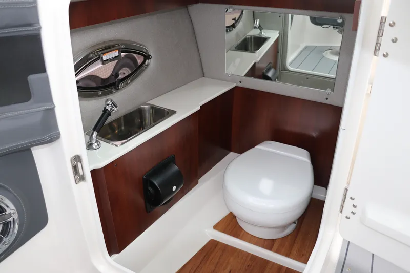 Slide: The Image of 2026 Chaparral 270 OSX boat bathroom with sink, toilet, and mirror. - 31
