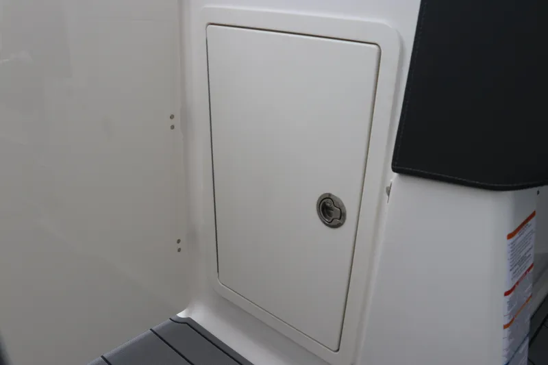 Slide: The Image of 2026 Chaparral 270 OSX boat storage compartment with secure latch. - 34