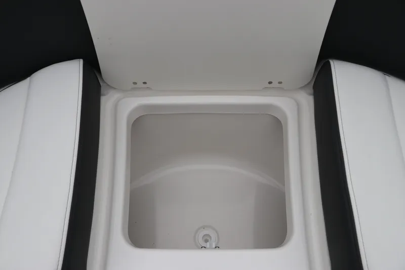 Slide: The Image of 2026 Chaparral 270 OSX boat storage compartment with white and black seating. - 51