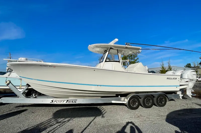 The Image of 2023 Regulator 34 boat on Sport Trail trailer under clear blue sky. - 0