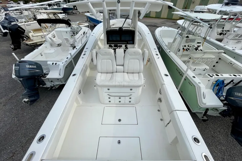 Slide: The Image of 2023 Regulator 34 boat with dual seats and Yamaha outboard, docked among other boats. - 15