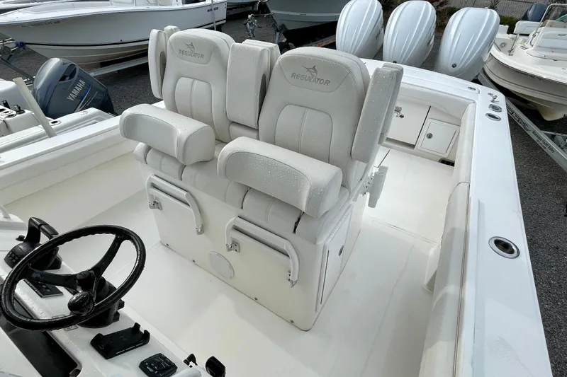 Slide: The Image of 2023 Regulator 34 boat interior with dual helm seats and steering wheel. - 17