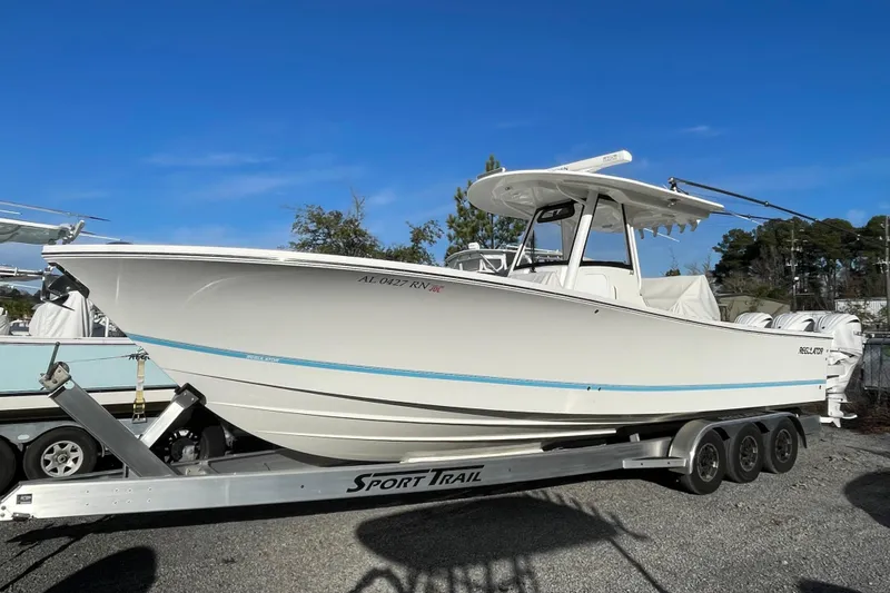 Slide: The Image of 2023 Regulator 34 boat on trailer, side view, clear sky background. - 2