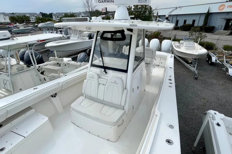 Slide: The Image of 2023 Regulator 34 boat with center console and seating, displayed in a marina setting. - 21
