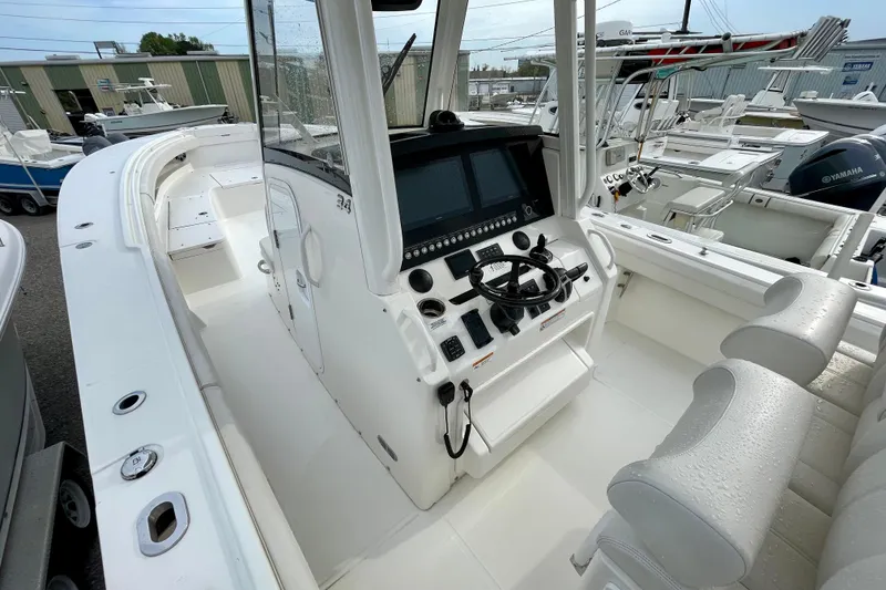 Slide: The Image of 2023 Regulator 34 boat cockpit with modern controls and seating in a marina setting. - 22