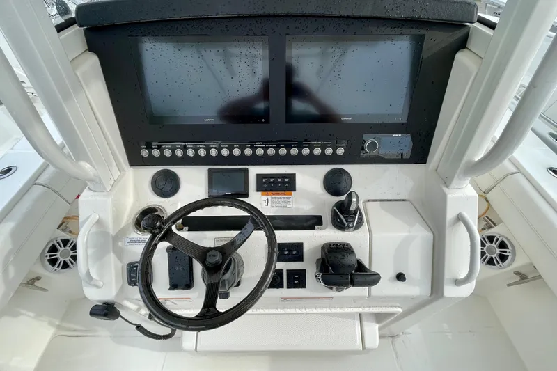 Slide: The Image of 2023 Regulator 34 boat dashboard with dual screens and steering wheel. - 24