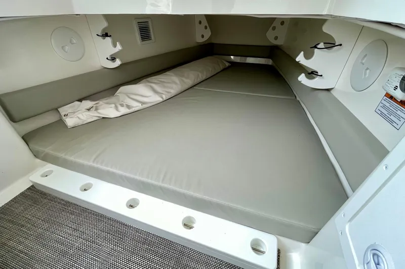 Slide: The Image of 2023 Regulator 34 boat cabin interior with cushioned seating and storage hooks. - 28