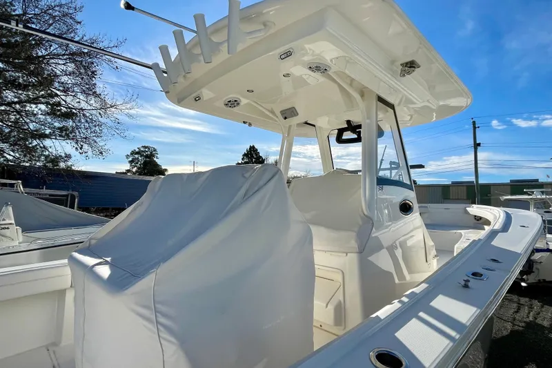 Slide: The Image of 2023 Regulator 34 boat with covered seating and T-top under a clear blue sky. - 4