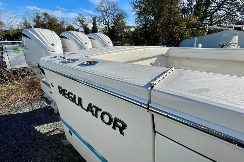 Slide: The Image of 2023 Regulator 34 boat with triple engines, sleek design, and spacious deck. - 7