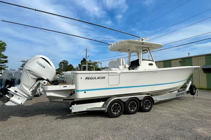 Slide: The Image of 2023 Regulator 34 boat with Yamaha engines on a trailer, parked outdoors. - 9