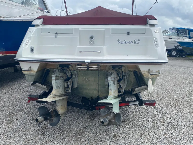 Slide: The Image of 1992 Regal Ventura boat with dual outboard motors on a gravel lot. - 2