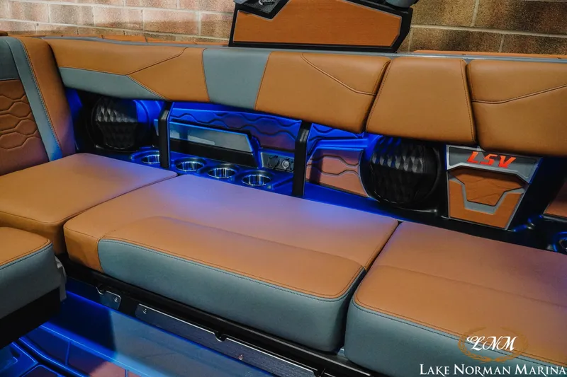 Slide: The Image of 2026 Malibu Wakesetter 23 LSV interior with brown and gray seating, blue LED lighting. - 12