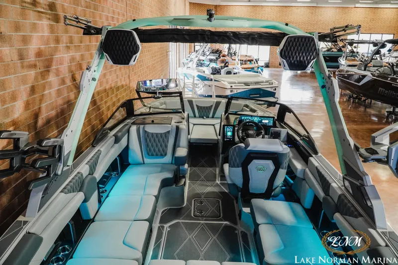 Slide: The Image of 2026 Malibu M230 boat interior with modern seating and advanced dashboard at Lake Norman Marina. - 10
