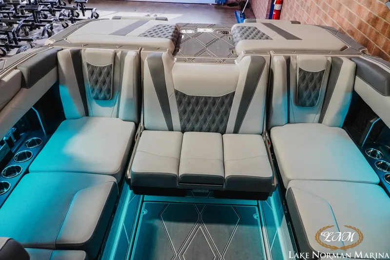 Slide: The Image of 2026 Malibu M230 boat interior with luxurious seating and cup holders at Lake Norman Marina. - 20