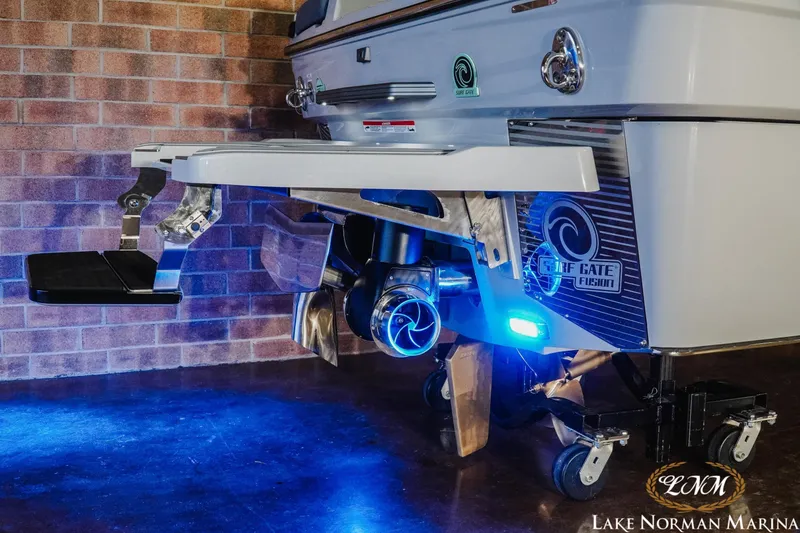 Slide: The Image of 2026 Malibu M230 boat with Surf Gate Fusion technology, illuminated by blue lights. - 7