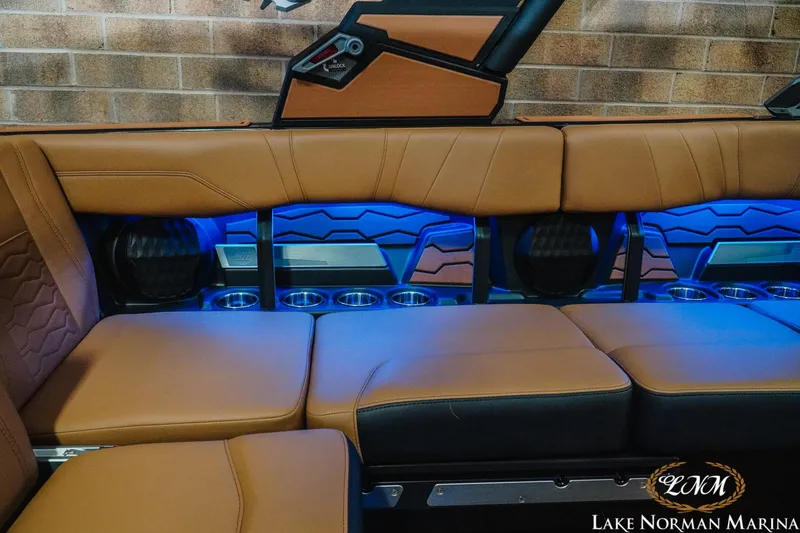 Slide: The Image of 2026 Malibu Wakesetter 23 MXZ interior with tan seating and blue LED lighting. - 22