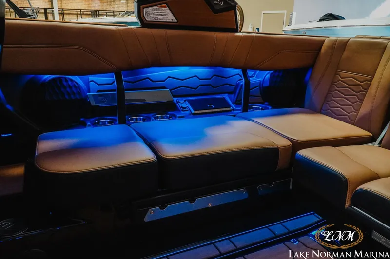 Slide: The Image of 2026 Malibu Wakesetter 23 MXZ interior with blue ambient lighting and brown seating. - 23