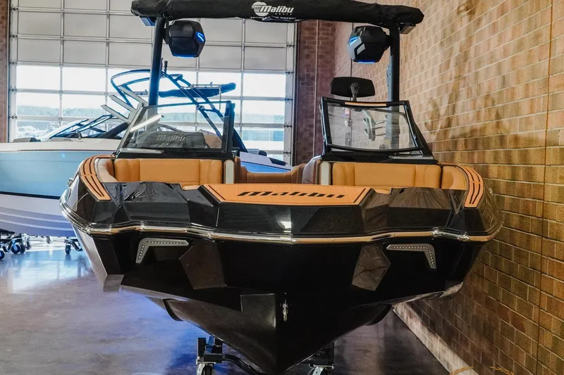 Slide: The Image of 2026 Malibu Wakesetter 23 MXZ boat in showroom, featuring sleek design and luxury seating. - 4
