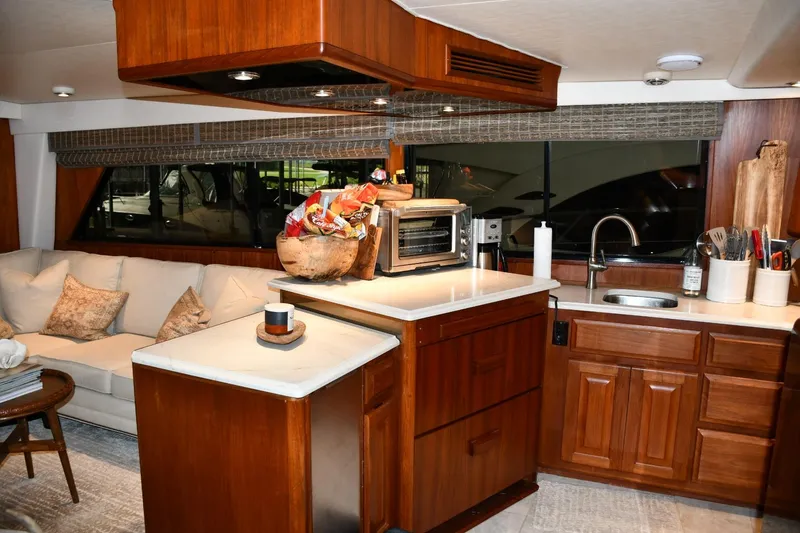Slide: The Image of Interior of 1990 Viking 53 Convertible yacht with modern kitchen and cozy seating area. - 12