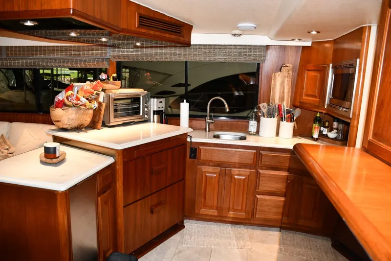 Slide: The Image of Luxurious kitchen interior of a 1990 Viking 53 Convertible yacht with wooden cabinetry. - 14