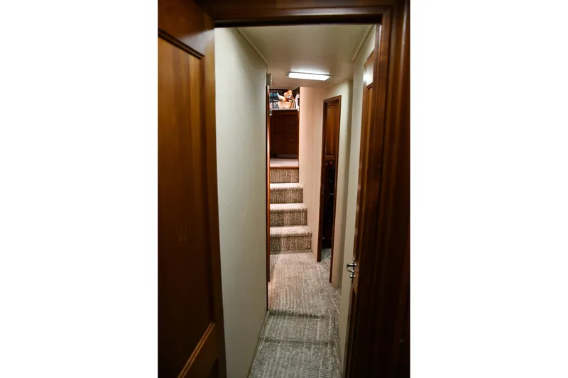 Slide: The Image of Interior hallway of 1990 Viking 53 Convertible yacht with carpeted stairs and wooden doors. - 18