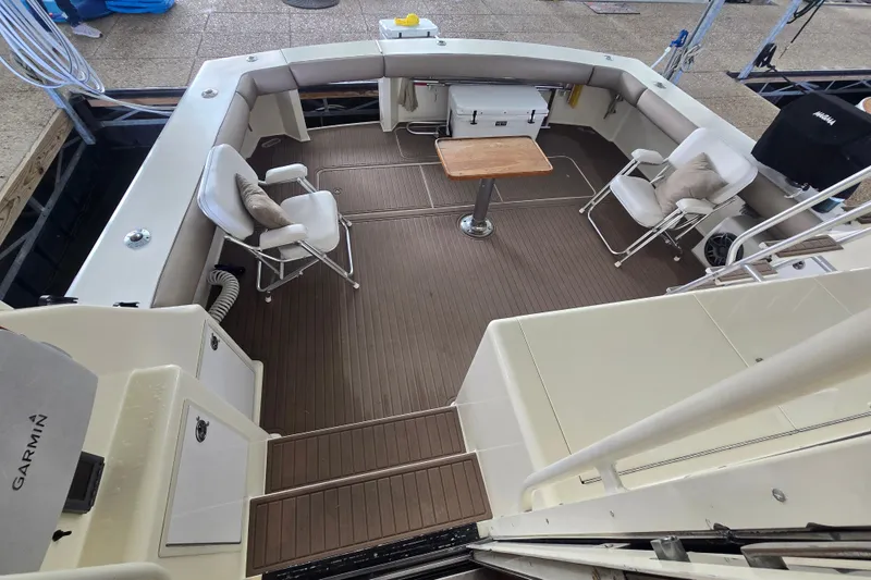 Slide: The Image of 1990 Viking 53 Convertible yacht deck with seating, table, and Garmin equipment. - 23