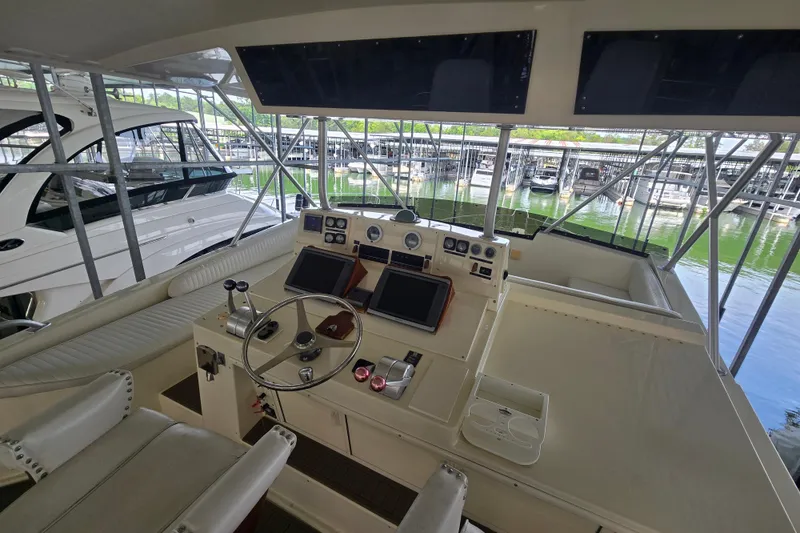 Slide: The Image of 1990 Viking 53 Convertible yacht helm with dual screens and marina view. - 24
