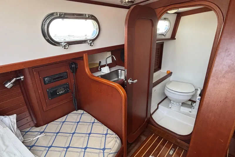 Slide: The Image of 1998 Hank Hinckley Great Harbor 26 boat interior with wooden finish, sink, and toilet. - 16