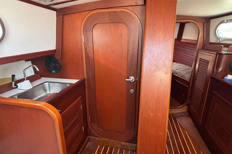 Slide: The Image of Interior of 1998 Hank Hinckley Great Harbor 26 boat with wooden cabinetry and compact sink. - 17