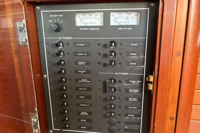 Slide: The Image of Electrical panel on a 1998 Hank Hinckley Great Harbor 26 boat, featuring DC and AC power controls. - 22