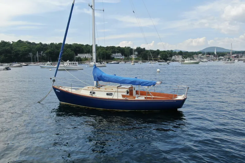 Slide: The Image of Sailboat "Hank Hinckley Great Harbor 26" from 1998 on calm waters, scenic harbor background. - 34