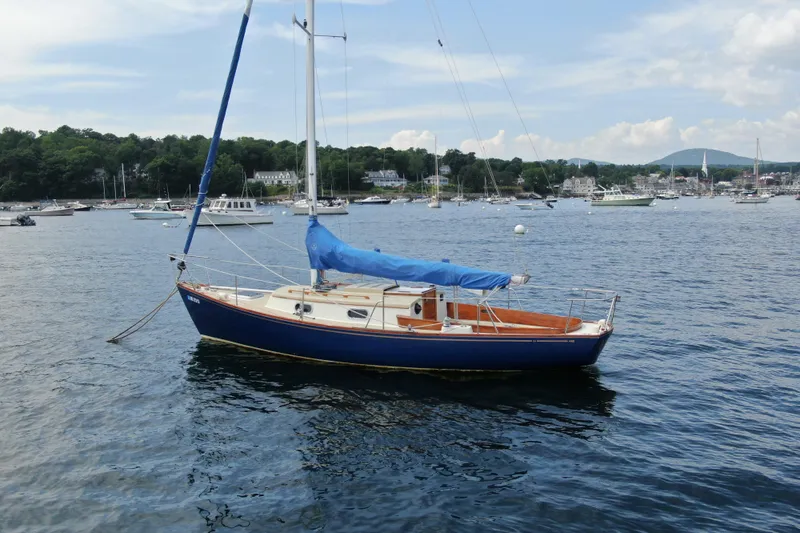 Slide: The Image of Sailboat "Hank Hinckley Great Harbor 26" from 1998 on calm waters, scenic harbor background. - 6