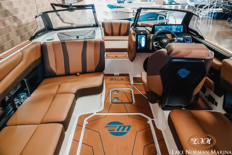 Slide: The Image of 2026 Malibu Wakesetter 21 LX interior with luxurious brown seating and modern dashboard. - 11