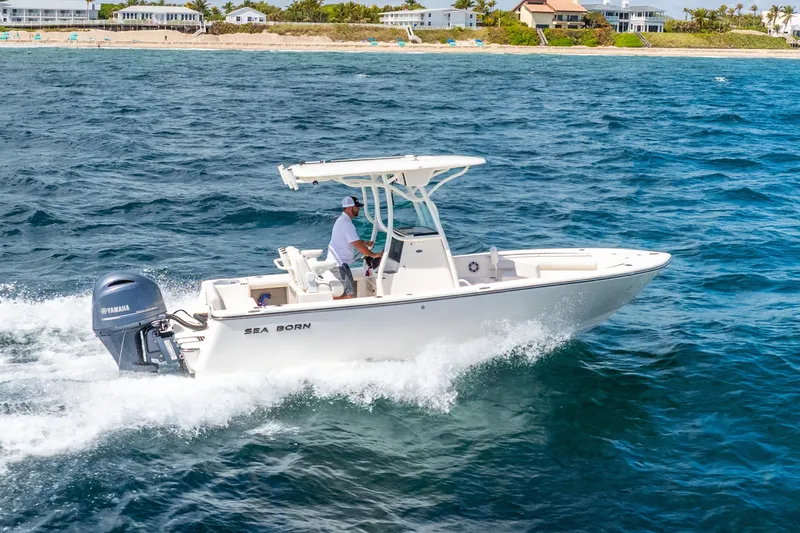 Slide: The Image of 2025 Sea Born LX22 Center Console boat cruising on ocean near sandy beach. - 16