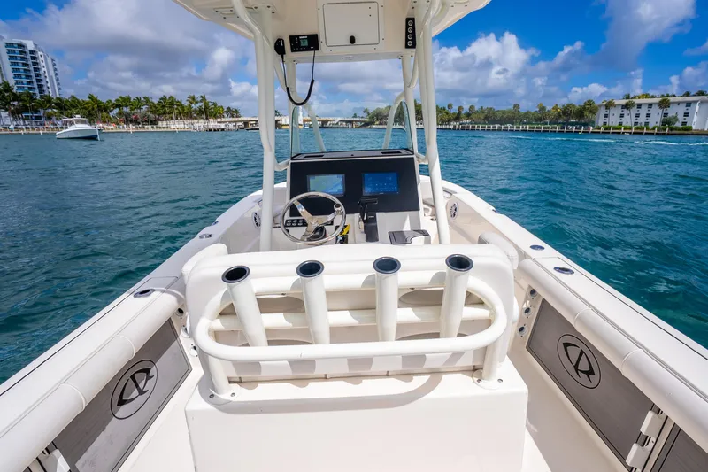 Slide: The Image of 2025 Sea Born LX22 Center Console boat on clear blue water, featuring modern helm and rod holders. - 24